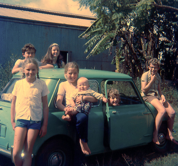 Owen at 13 years with siblings and cousins around a mini minor car at the farm